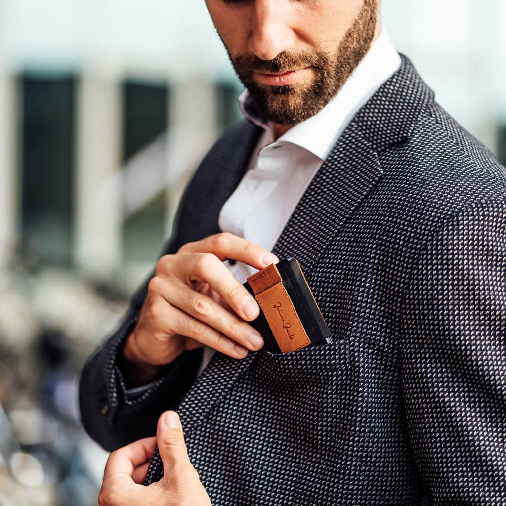 men slips small nano boy pocket card holder into his jacket's breast pocket